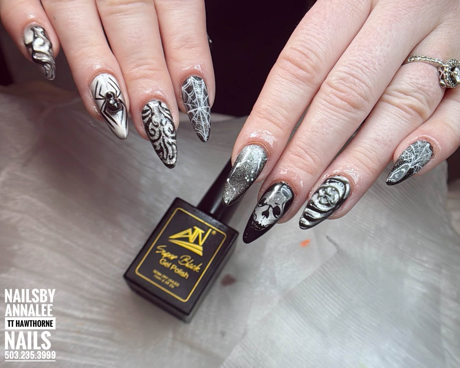 Black and silver Halloween nails with skull, spider and web details by Le Nguyen at TT Hawthorne Nails, photographed with ATN Super Black gel polish.